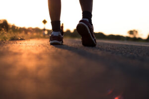 Runner corre su strada con il sole che sorge.